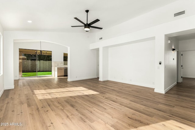 unfurnished living room with ceiling fan with notable chandelier, lofted ceiling, baseboards, and wood finished floors