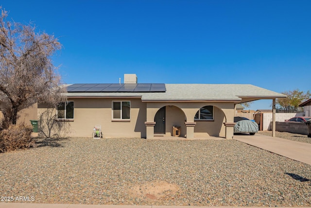 view of front facade with an attached carport, driveway, fence, and stucco siding