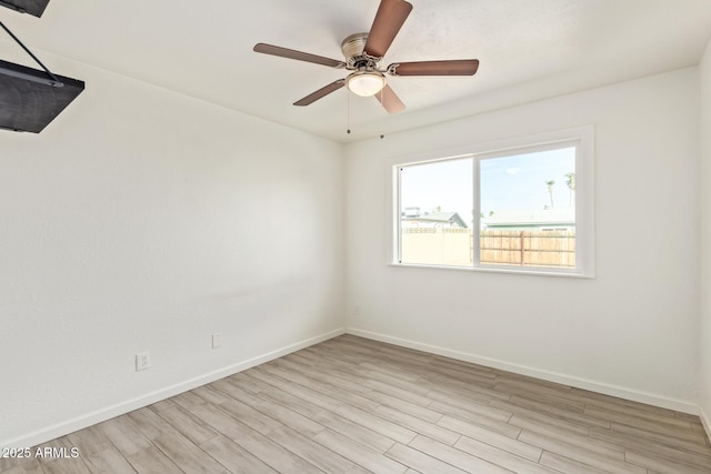 spare room featuring light wood-style floors, ceiling fan, and baseboards