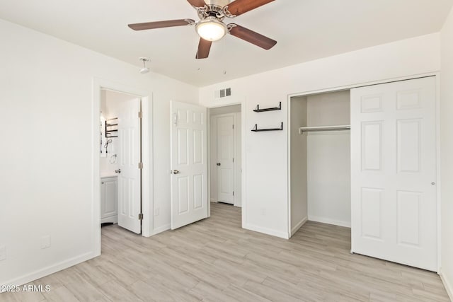 unfurnished bedroom with a closet, light wood-type flooring, visible vents, and baseboards