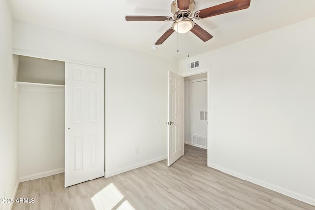 unfurnished bedroom with a closet, visible vents, and wood finished floors