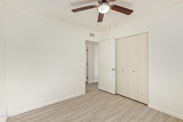 unfurnished bedroom with a closet, visible vents, a ceiling fan, light wood-type flooring, and baseboards