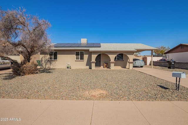 ranch-style house with a carport, driveway, fence, and stucco siding