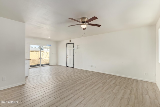 spare room with light wood-style floors, baseboards, and a ceiling fan