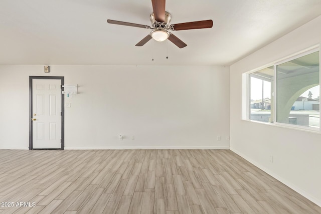 unfurnished room with a ceiling fan, light wood-style flooring, and baseboards