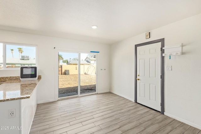 entryway featuring baseboards and light wood finished floors