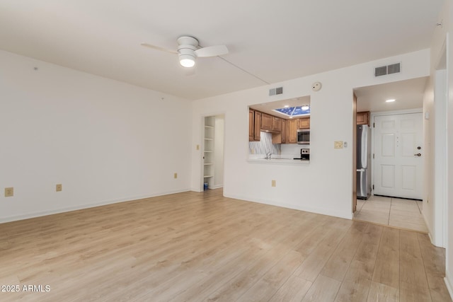 10330 W Thunderbird Blvd Unit C109, Sun City, AZ 85351 - unfurnished living room featuring a ceiling fan and light wood-style floors