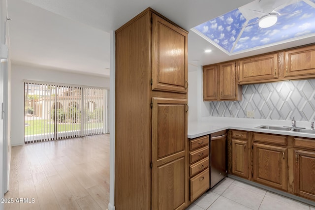 10330 W Thunderbird Blvd Unit C109, Sun City, AZ 85351 - kitchen featuring stainless steel dishwasher, brown cabinets, light countertops, backsplash, and light wood-type flooring