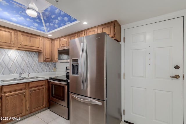 10330 W Thunderbird Blvd Unit C109, Sun City, AZ 85351 - kitchen with stainless steel appliances, light countertops, light tile patterned floors, decorative backsplash, and brown cabinetry