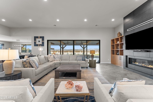 living area featuring baseboards, a fireplace, built in features, and recessed lighting