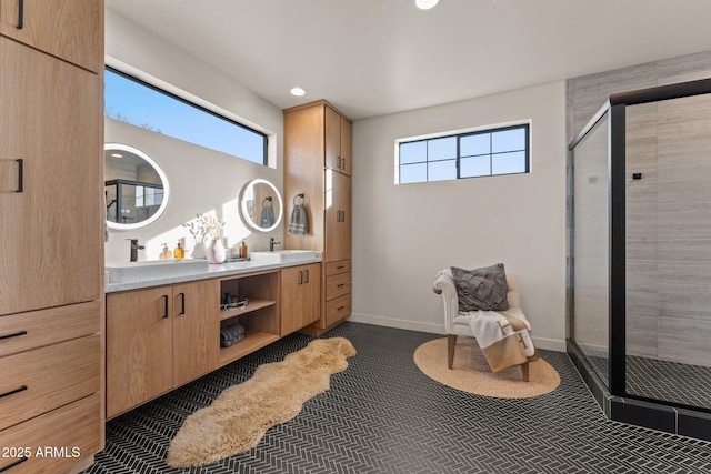 bathroom featuring double vanity, a stall shower, and a healthy amount of sunlight