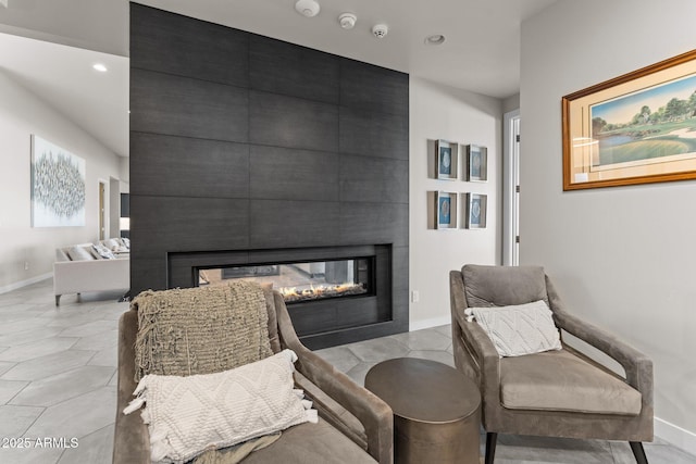 sitting room featuring recessed lighting, baseboards, and a multi sided fireplace