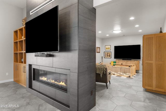 living room featuring baseboards, a fireplace, and recessed lighting