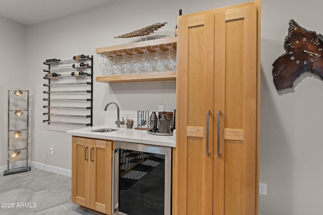 bar featuring wine cooler, baseboards, a sink, and wet bar