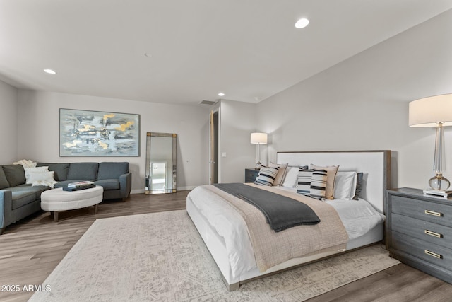 bedroom with dark wood-style floors and recessed lighting