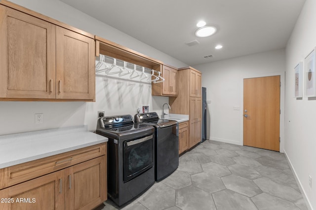 laundry room with cabinet space, baseboards, washer and dryer, a sink, and recessed lighting