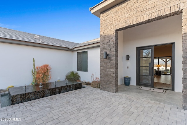 property entrance with a patio area and stucco siding