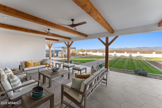 view of patio featuring an outdoor hangout area, ceiling fan, and a mountain view