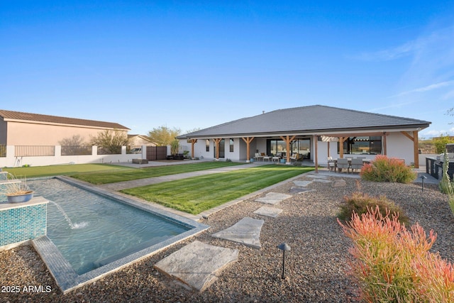 rear view of house with a patio, fence, a lawn, and stucco siding