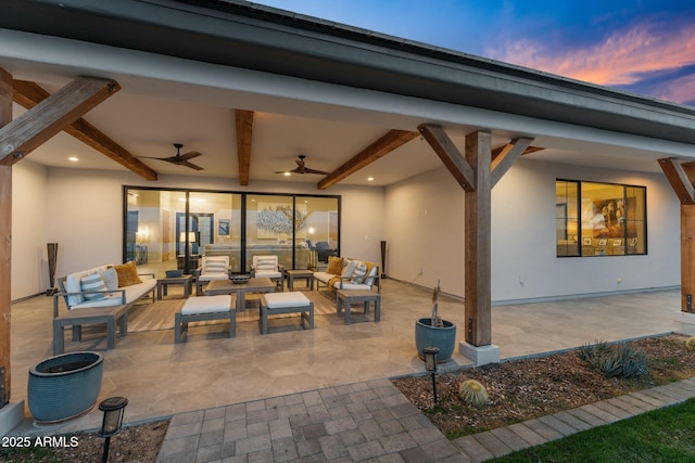 patio terrace at dusk featuring an outdoor hangout area and a ceiling fan