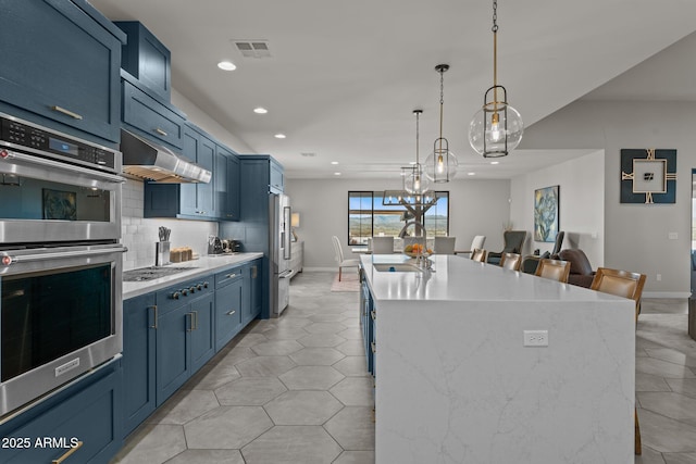 kitchen with light countertops, a kitchen bar, and under cabinet range hood