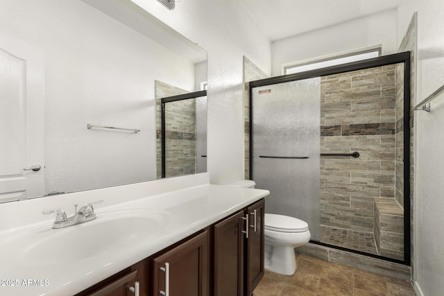 bathroom featuring vanity, toilet, and a shower with door