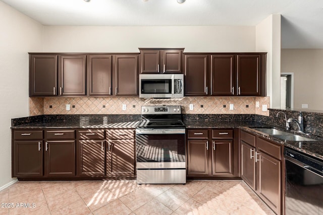 kitchen with stainless steel appliances, dark brown cabinets, sink, and dark stone counters