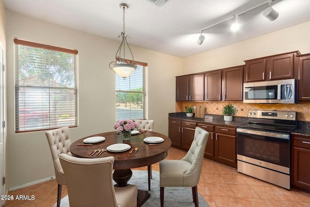 kitchen featuring light tile patterned flooring, appliances with stainless steel finishes, pendant lighting, decorative backsplash, and dark brown cabinetry