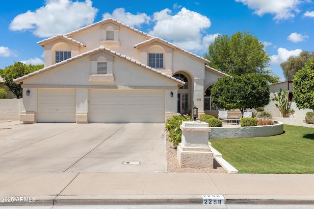 2258 N Gentry, Mesa, AZ 85213 - mediterranean / spanish-style house featuring a garage, concrete driveway, stucco siding, and a front lawn