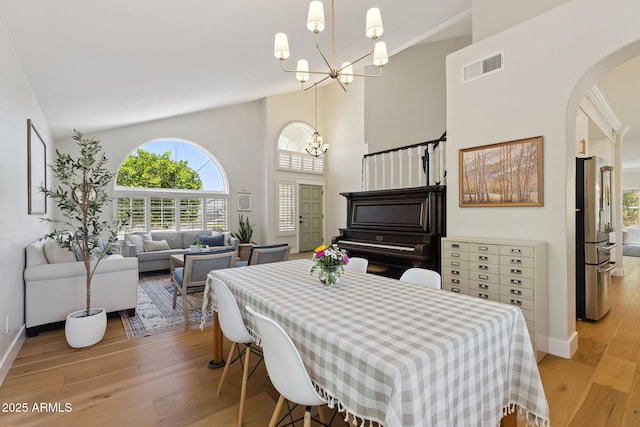 2258 N Gentry, Mesa, AZ 85213 - dining space featuring a chandelier, light wood-style floors, arched walkways, and a towering ceiling
