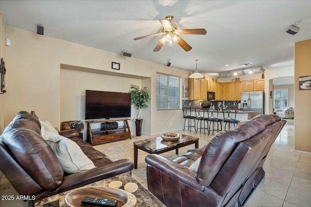 tiled living room featuring ceiling fan and plenty of natural light