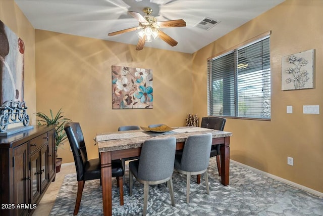 dining area featuring ceiling fan and light carpet