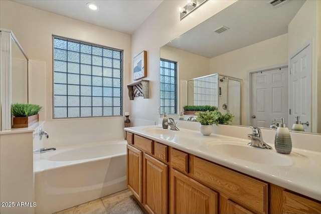 bathroom featuring plus walk in shower, tile patterned flooring, and vanity