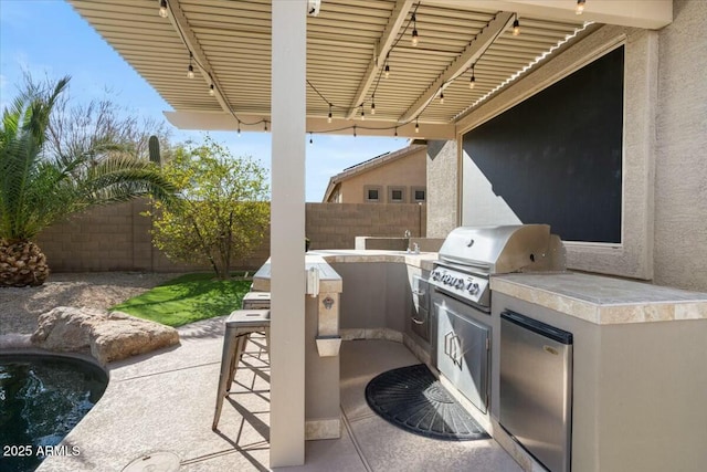 view of patio with exterior kitchen, an outdoor bar, and grilling area