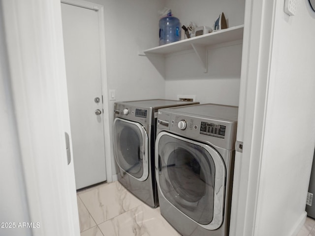 washroom featuring separate washer and dryer, marble finish floor, and laundry area