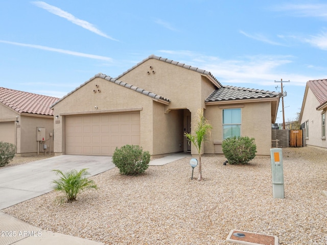 mediterranean / spanish home featuring stucco siding, a garage, driveway, and a tiled roof