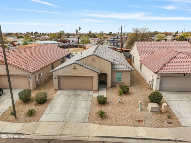 view of front of house featuring a tile roof, a garage, driveway, and stucco siding