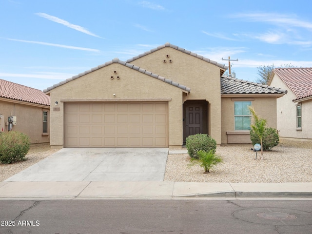 mediterranean / spanish-style home with stucco siding, concrete driveway, an attached garage, and a tile roof