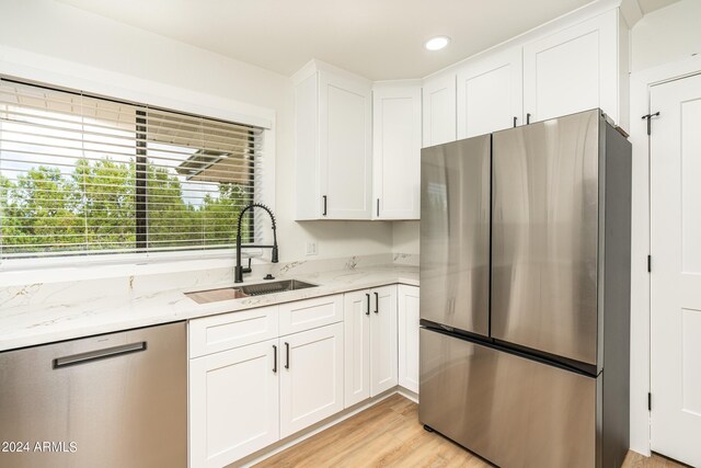 kitchen featuring sink, appliances with stainless steel finishes, and white cabinetry