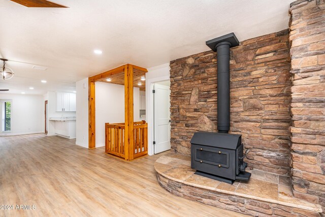 unfurnished living room with hardwood / wood-style floors and a wood stove