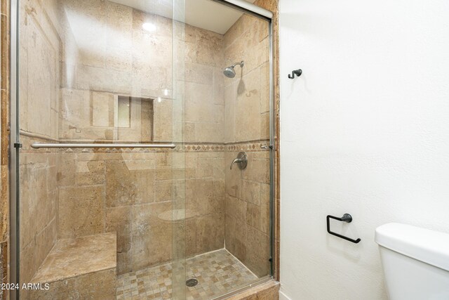 unfurnished bedroom featuring ensuite bath, light wood-type flooring, a walk in closet, a closet, and ceiling fan