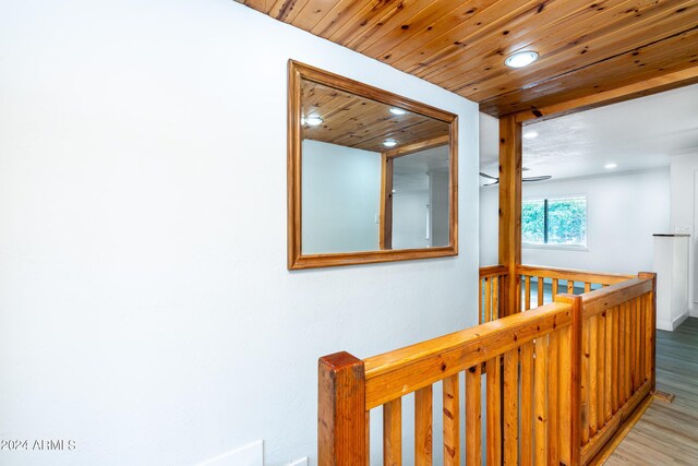 laundry area featuring light wood-type flooring, wood ceiling, cabinets, and washing machine and clothes dryer