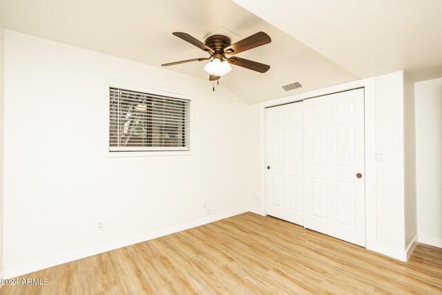 unfurnished bedroom featuring lofted ceiling, ceiling fan, a closet, and light hardwood / wood-style floors