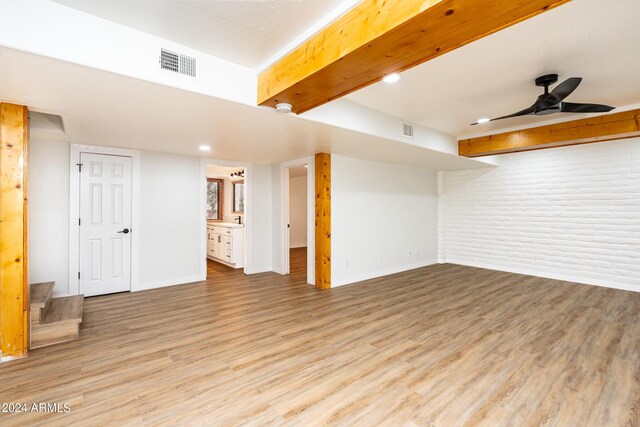 spare room featuring brick wall, ceiling fan, and wood-type flooring