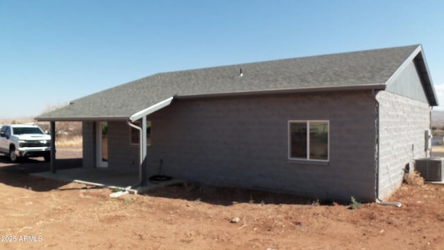 view of side of property with central AC unit and a patio area