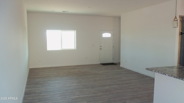 interior space with baseboards and wood finished floors