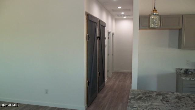 corridor featuring recessed lighting, visible vents, baseboards, and wood finished floors