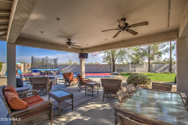 view of patio with a fenced in pool, ceiling fan, an outdoor living space, and a trampoline