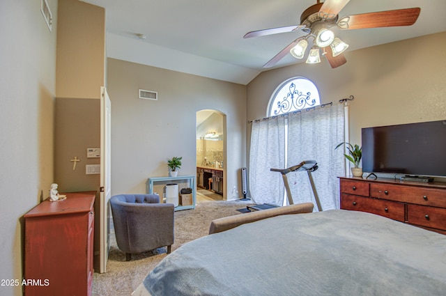 bedroom with vaulted ceiling, light colored carpet, ensuite bath, and ceiling fan