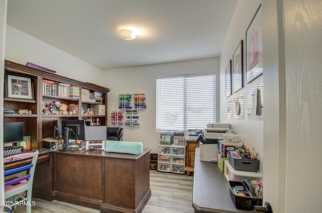 home office with light hardwood / wood-style flooring